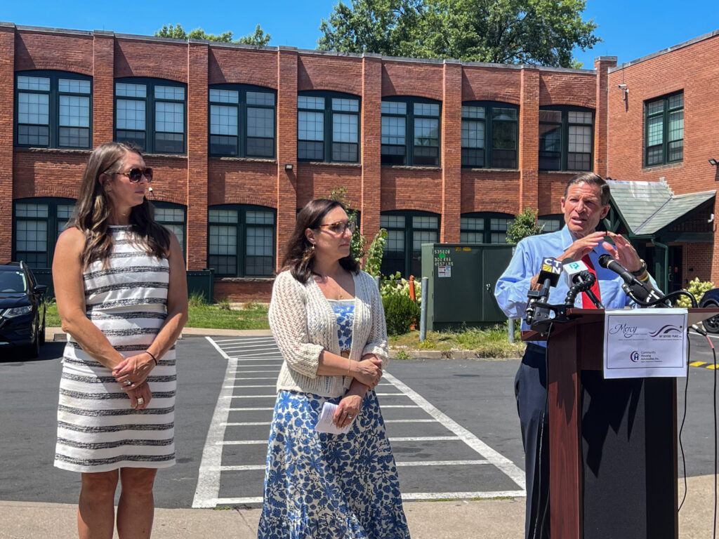 Amy Pelletier of the Partnership for Strong Communities, CEO Kara Capone, and Senator Richard Blumenthal outside the Beaumont Lofts.